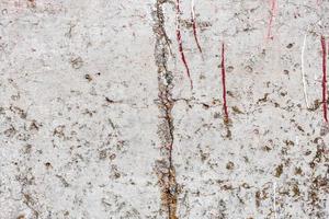 Texture of a concrete wall with cracks and scratches which can be used as a background photo