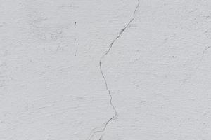 Texture of a concrete wall with cracks and scratches which can be used as a background photo