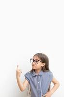 A 7-year-old girl with glasses points a finger up. Children's education, learning concept. Vertical format with copy space photo