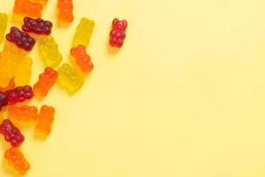 Colored jelly bears on an yellow background with copy space. Top view photo
