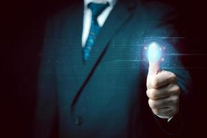 Businessman scans his fingerprint to access personal financial data. Futuristic business technology security concept. Innovation technology against digital cybercrime. Biometrics identity. photo
