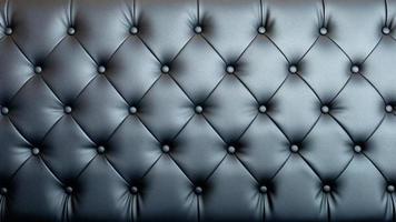 Black artificial leather sofa with rivets texture for background. photo