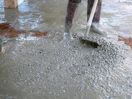 The plasterer is cleaning the cement floor to be smooth. photo