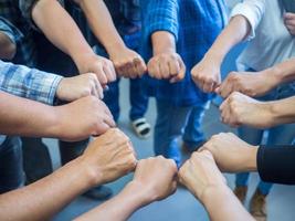 Close-up of many people putting their fists together as symbol of unity photo