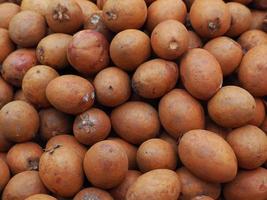 Pile of sapodilla fruit for sale in the market photo