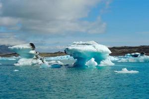Bright clear blue iceberg floating in the Jokulsarlon lake blue cold water in Iceland 37 photo