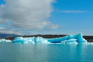 Bright clear blue iceberg floating in the Jokulsarlon lake blue cold water in Iceland 17 photo