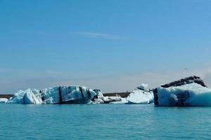 Bright clear blue iceberg floating in the Jokulsarlon lake blue cold water in Iceland 8 photo