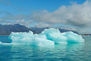 Bright clear blue iceberg floating in the Jokulsarlon lake blue cold water in Iceland 41 photo
