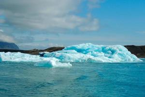 Bright clear blue iceberg floating in the Jokulsarlon lake blue cold water in Iceland 2 photo