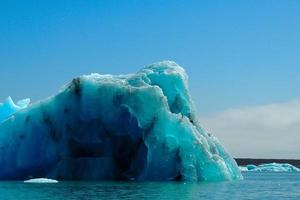 Bright clear blue iceberg floating in the Jokulsarlon lake blue cold water in Iceland 6 photo