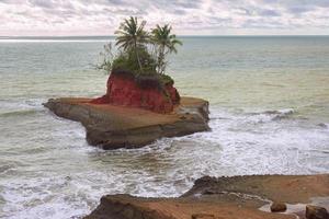 una playa con su propia isla en medio del océano foto