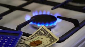escasez y crisis del gas. dinero y una calculadora en el fondo de una estufa de gas en llamas video