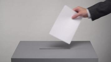 graue Wahlurne. Präsidentschafts- und Parlamentswahlen. der Wähler wirft den Stimmzettel in die Wahlurne
