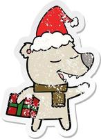 distressed sticker cartoon of a bear with present wearing santa hat vector