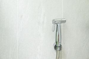 Rinse spray in toilet. Bidet spray or Rinsing spray hanging with space for text. photo