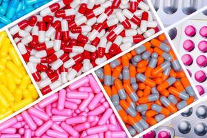 Top view of antibiotic capsules and tablet pills. Antibiotic drug resistance. Superbug. Full frame of multi-colored pills. Pharmaceutical industry. Prescription drugs. Healthcare and medicine. photo