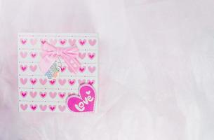 caja de regalo con patrón de corazón sobre fondo de papel rosa, festival de san valentín foto