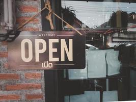 A sign in a close-up cafe with the words Welcome to Open. photo