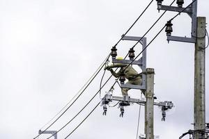 instalación segura y sistemática de electricistas en postes de alta tensión. trabajo en postes eléctricos con la máxima seguridad foto