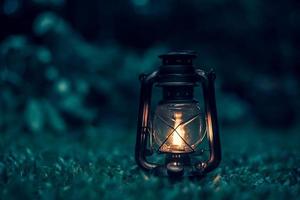 antique kerosene lamp on the grass in the forest at night.soft focus. photo