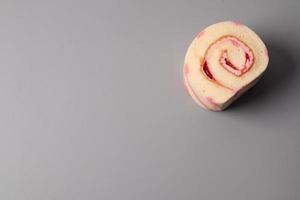 Strawberry swiss roll cake on gray background photo