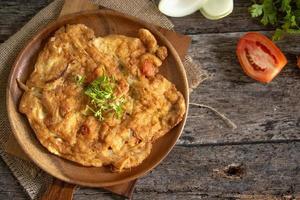 Omelet in a plate on a wooden background photo