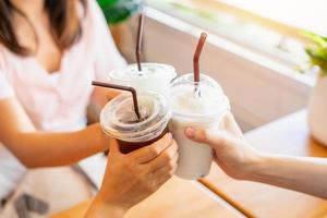 Group of friends cheering with drinks in cafe photo