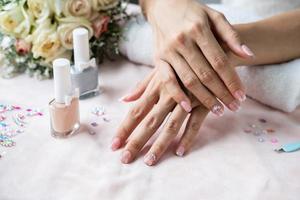 Beautiful manicure nails paint with glitter, gems and varnish in nail salon photo