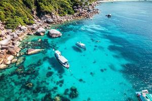 Boats and crystal clear waters at the bay dive site in Koh Tao,diving tour boat photo