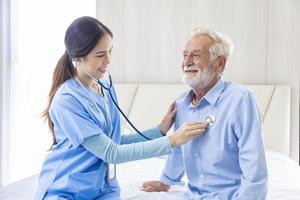Hospice nurse is using stethoscope on Caucasian man in bed for diagnosing lung cancer and heart rate in pension retirement center for home care rehabilitation and post treatment recovery process photo