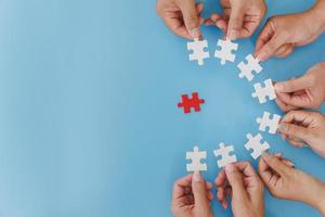 Group of business people assemble jigsaw puzzles on blue background,  teamwork, help and support in business, symbol of association and connection. business strategy. photo