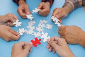 Group of business people assemble jigsaw puzzles on blue background,  teamwork, help and support in business, symbol of association and connection. business strategy. photo