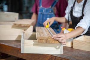 A carpenter works with equipment on a wooden table in a carpentry shop. photo