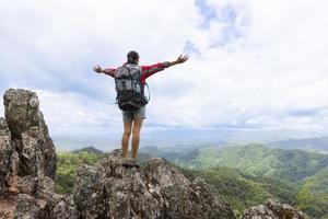 Freedom traveler woman standing with raised arms and enjoying a beautiful nature. photo