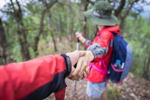 Couple of hikers with backpacks looking over mountains view. Hiking and leisure theme photo