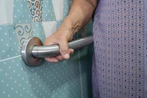 Asian senior or elderly old lady woman patient use toilet bathroom handle security in nursing hospital ward, healthy strong medical concept. photo