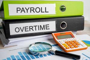 Payroll and Overtime. Binder data finance report business with graph analysis in office.