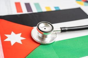 Black stethoscope on Jordan flag background with graph, Business and finance concept. photo