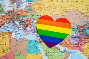 Rainbow color heart on world map background, LGBT pride month celebrate annual in June social, symbol of gay, lesbian, bisexual, transgender, human rights and peace. photo