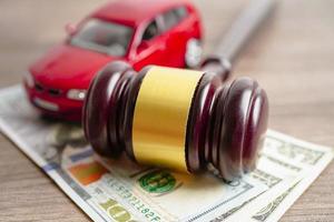 Gavel for judge lawyer with car on US dollar money banknotes, Car loan, Finance, saving money, law, insurance and leasing time concepts. photo