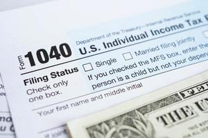 Tax Return form 1040 and dollar banknote, U.S. Individual Income. photo