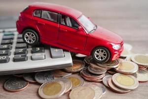 BANGKOK, THAILAND - MAY 18, 2022 Car on coins and calculator Car loan, Finance, saving money, insurance and leasing time concept. photo