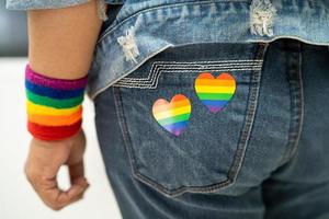 dama asiática con el corazón de la bandera del arco iris, símbolo del mes del orgullo lgbt celebra anualmente en junio social de gay, lesbiana, bisexual, transgénero, derechos humanos. foto