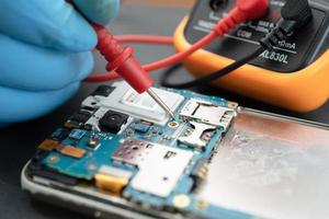 Technician repairing inside of mobile phone by soldering iron. Integrated Circuit. the concept of data, hardware, technology. photo