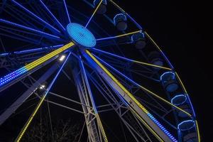 Ferris wheel beautifully illuminated at night in Leeds by the City Town Hall. photo