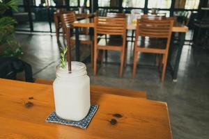 coconut water frappe with rosemary leaf on restaurant table photo