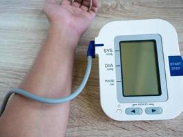 man using digital blood pressure monitor photo