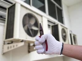 technician installing outdoor air conditioning unit photo