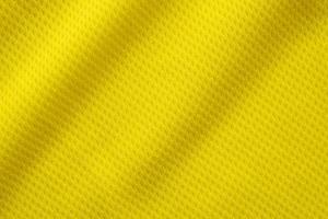 Yellow color football jersey clothing fabric texture sports wear background, close up photo